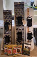 Three boxed West Rage snowboards with black bindings, two visible slide on runner packages and a hockey bag package in front.