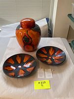 Three-piece Poole Pottery set with one large ginger jar and two Galaxy design dishes on white background.