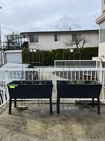 Two raised planters side by side with four metal arch trellises inserted, shown on outdoor patio.
