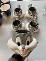 Four Bugs Bunny ceramic mugs shaped as character heads, photographed from front and top to show details