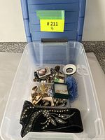 Plastic bin containing assorted costume jewelry, hair accessories and other miscellaneous items