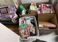 Overview of multiple bins and boxes containing assorted vintage kids toys
