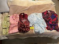Full view of six silky sleepwear sets laid out showing different colors and styles