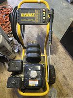 Top-down view of entire pressure washer showing DeWalt control panel and coiled hose