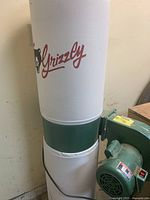 Front view showing cloth filter bag with Grizzly logo and green lower housing
