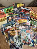 Photo showing full lot of 13 vintage comic books overlapping on table surface, titles visible including Swamp Thing, Buck Rogers, Master of Kung Fu, The Tomb of Dracula.