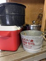 Shows red and white Rubbermaid cooler, black and white speckled canning bath, and galvanized Christmas drinks bucket