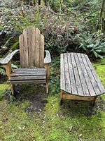 Wide view of Adirondack chair and low table sitting outdoors, showing wood surface texture and condition