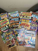 Photo of 14 Marvel Comics Group superhero comic books including X-Men, Hulk, Avengers, Thor, Fantastic Four, Iron Man, Flash, Captain America, Black Panther, Nova, Plastic Man, and additional titles.