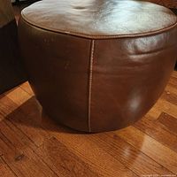 Side view showing the brown leather surface with visible stitching and minor wear marks.