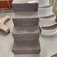 Front view of brown fabric pet steps showing texture and 4 steps