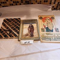 Three antique books laid out side by side: The Manger Babe, Scottish Songs, and a third book with a plaid cover. The photo shows condition and details of covers.