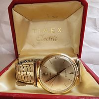 Vintage Timex Electric wristwatch displayed in original red box with cream satin interior stamped 'TIMEX Electric'
