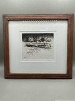 Full view of framed black and white etching artwork depicting two figures near a wooden fence in a rustic setting.