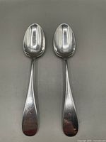 Two antique sterling silver tablespoons front view showing shape and engraving