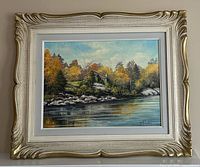 Full front view of the framed oil painting showing fall day waterside landscape and artist signature.