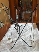 Photo of jewelry tree stand with four necklaces hanging.