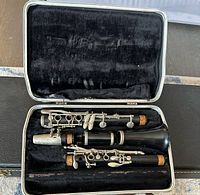 Black clarinets in fitted black velvet case, showing condition inside violin case