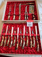 Overview of open red satin-lined case showing all utensils