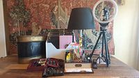 Photo showcasing the desktop ring light on tripod, black vintage style lamp, vintage metal trash can, file folder organizer with folders, travel desk kits, and letter openers.