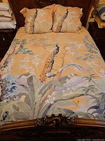 Queen bed with brown and tan peacock printed comforter or duvet cover and matching pillow shams.