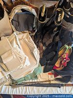 Photo of multiple women's shoes, boots, and storage accessories including beige fabric dust bags and closet organizers, laid out on a surface.