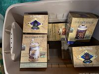Top view showing eight Budweiser Endangered Species Steins in original packaging inside a storage bin.