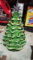 Full view of ceramic Christmas tree with colorful bulbs and clear star.