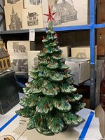 Front view of ceramic Christmas tree with red star topper, detailed leaf texture, and multicolored bulbs.