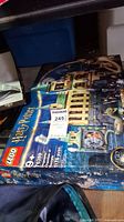 Sealed box for LEGO Harry Potter set 76389, Hogwarts Chamber of Secrets, 1176 pieces, ages 9+. Box shows wear with fading and corner damage.