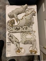 Overhead photo of all four porcelain figurines — Santa, sleigh, and two reindeer — arranged in original white foam packaging.