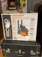 Image showing front and side of the Ridgid WD4070 portable wet/dry vacuum in original box with product features and branding visible.