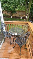 Full set of outdoor metal table with two matching decorative metal chairs and plastic rustic chair