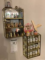 Three glass and mirror shelf units mounted on wall holding assorted ceramic thimbles, character mugs, and other figurines.