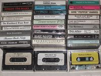 All 35 cassette tapes stacked in three columns with two loose tapes and storage case