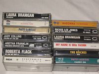 Front spines of 12 stacked cassettes showing artist and album titles