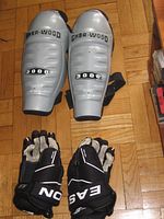 Sher-Wood 5000 shin guards and Easton gloves on parquet floor