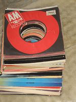 Stack of assorted 7-inch record sleeves showing A&M Records top sleeve