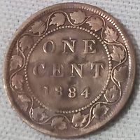 Reverse of the 1884 Canadian one cent coin showing denomination and date within a maple leaf wreath.