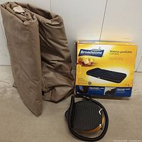 Broadstone single inflatable air mattress folded and a foot pump placed beside it, showing material and color