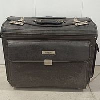 Front view of the Bugatti black rolling briefcase showing brand plate on front pocket and clasp