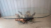 Front view of the glass top table showing the detailed horse sculpture base and the large clear glass surface.