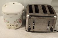 Rice cooker and four slice toaster together showing size and appearance of both appliances.