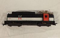 Side view of vintage Lionel NH toy train car, showing black, white, and red color scheme with number 0581 and NH markings