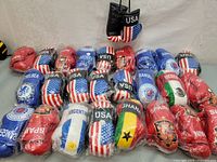 Photo of 25 mini boxing gloves laid out, showing various national flags and team logos including USA, Spain, Argentina, Ghana, Chelsea, Rangers, and Mexico.