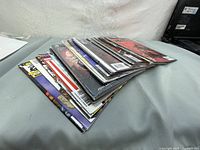 Stack of approximately 15 assorted comic books laid on a surface.