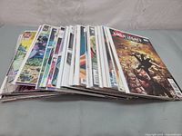 Stack of comic books with visible titles including 'X-Men Legacy' at the top