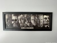 Full view of the framed Sons of Anarchy poster showing seven character portraits and the series title at the bottom.