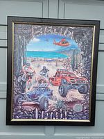 Full view of the framed motocross painting showing the off-road racing scene with riders, vehicle, and helicopter.
