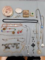 Photo showing assorted vintage and modern jewelry including necklaces, earrings, bracelets, and small decorative boxes for safe keeping.